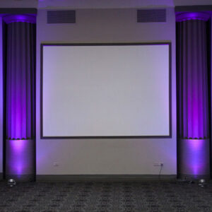 A room with purple lighting and a projection screen.