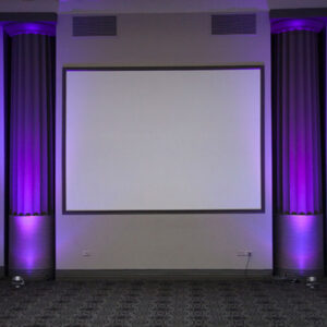 A room with purple lighting and a projection screen.