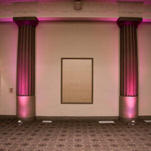 A room with pink lighting and pillars.