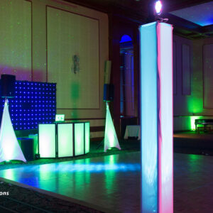 A dance floor with colorful lights and a dj booth.