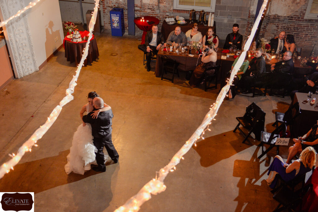 A bride and groom sharing their first dance in a warehouse.