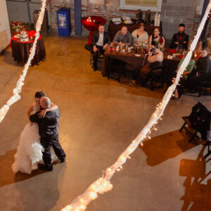 A bride and groom sharing their first dance in a warehouse.