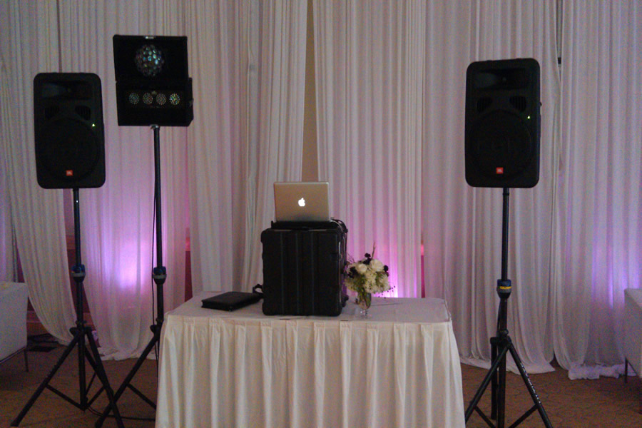 A table with speakers and a laptop on it.
