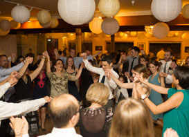 A group of people dancing at a wedding reception.