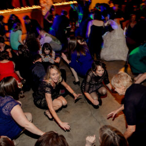 A group of people dancing at a wedding reception.