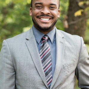 A smiling black man in a suit and tie resembling Richard Cohen.