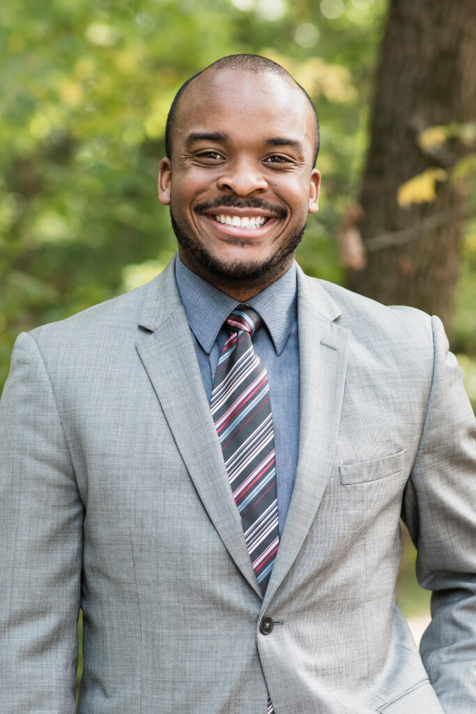 A smiling black man in a suit and tie resembling Richard Cohen.