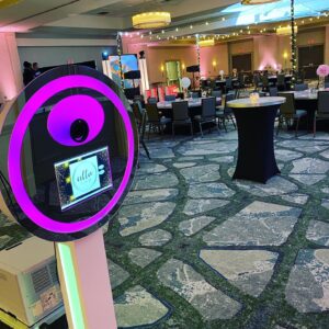 A photo booth rental Georgia in a room with tables and chairs.