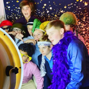 A group of people having fun and posing for pictures in a photo booth at a Bat/Bar Mitzvah celebration.