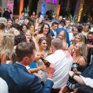 A group of people dancing at a wedding reception.