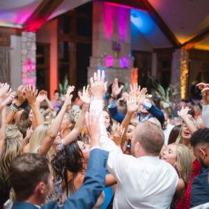 A group of people dancing at a wedding reception.