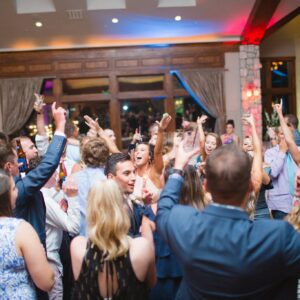 A group of people dancing at a wedding reception.