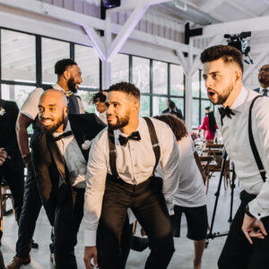 A group of men dancing at a wedding reception.