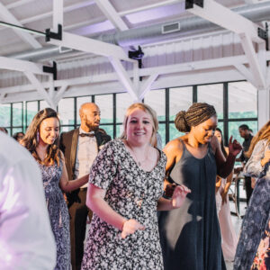 A group of people dancing at a wedding reception.