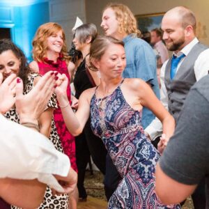 A group of people dancing at a wedding reception.