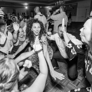 A group of people dancing on the dance floor at a wedding.