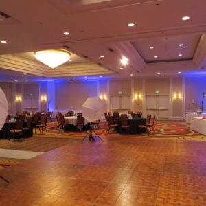 A large ballroom with tables and chairs.