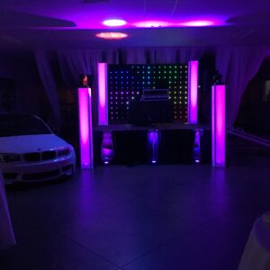 A room with purple lights and a car in the background.