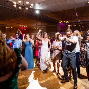 A group of people dancing at a wedding reception.