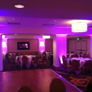 A banquet room with purple lighting and tables.