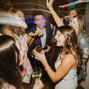 A group of people dancing at a wedding reception.