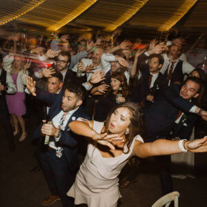 A group of people dancing at a wedding reception.