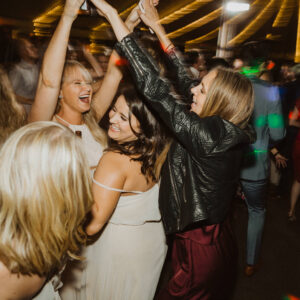 A group of bridesmaids dancing at a wedding reception.