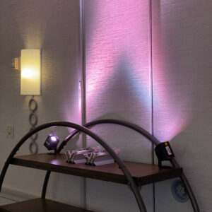 A shelf with a lamp on it next to a wall.