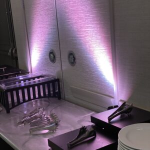A table with purple lights and plates on it.