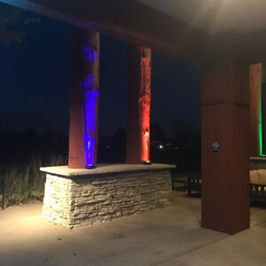 Lighted columns at night at the entrance to a golf course.