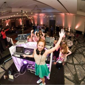 A young girl showcasing her live DJ set at a vibrant party.