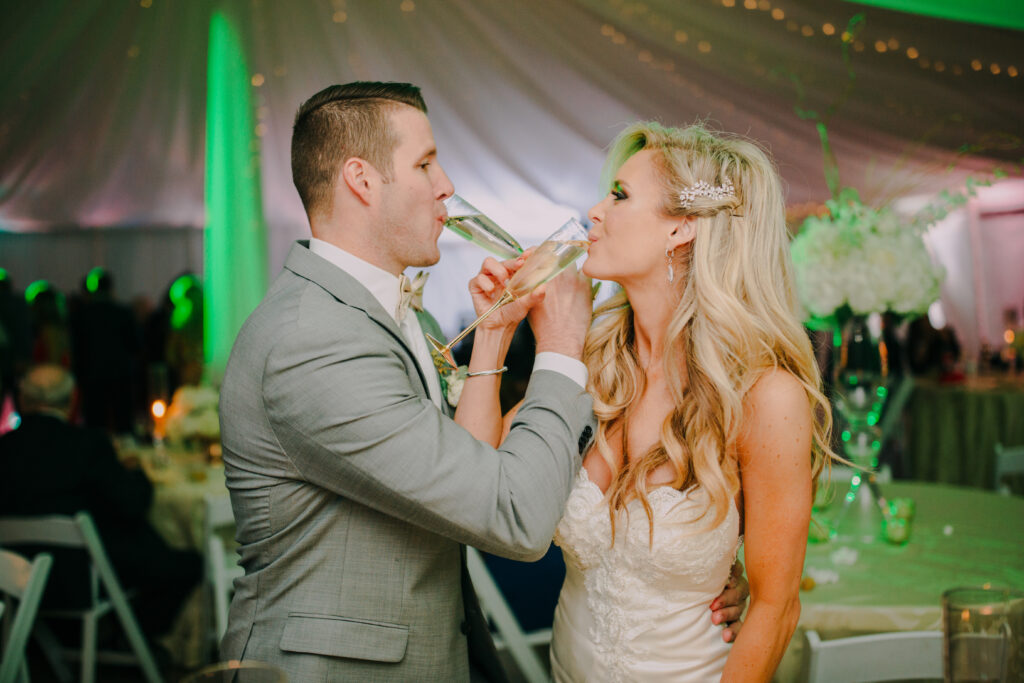 A bride and groom sharing a glass of wine at their wedding reception, captured beautifully at the photo booth rental in Georgia.