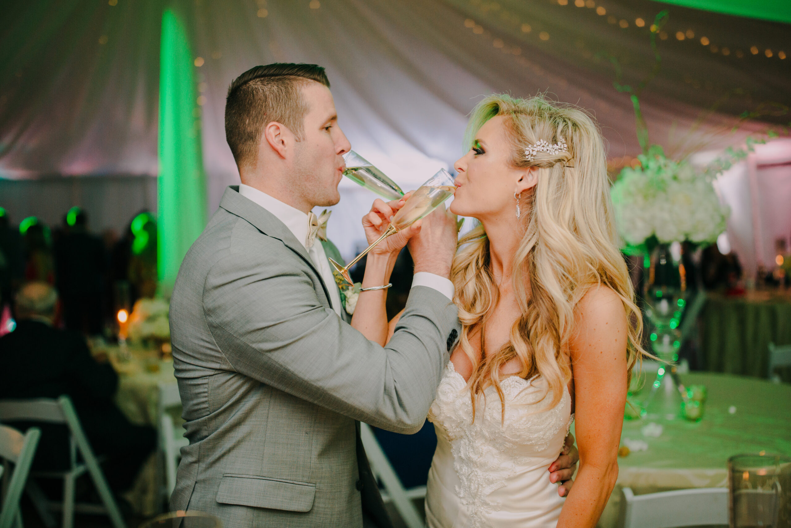 A bride and groom sharing a glass of wine at their wedding reception, captured beautifully at the photo booth rental in Georgia.