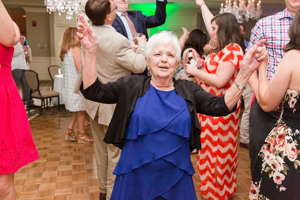 A woman is dancing on the dance floor at a wedding, enjoying the tunes from a renowned Georgia corporate DJ service.