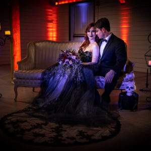 A bride and groom sitting on a couch in a dark room, enjoying the Georgia wedding DJ service.