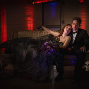 A bride and groom posing on a couch in a dark room, captured by their Georgia wedding DJ's photography service.