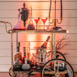 A bar cart with a lot of drinks on it, featuring a photo booth rental Georgia setup for capturing memorable moments.