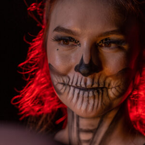 A woman with skeleton makeup and red hair at a Georgia wedding DJ event.