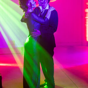 A man and woman hugging in front of a neon light at their Georgia wedding.