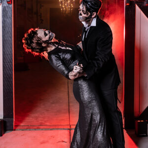 A man and woman in a black dress are dancing in front of a red door at a Georgia corporate DJ event.