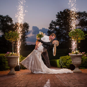A bride and groom kissing in front of sparklers, celebrating their Georgia wedding DJ-powered reception.