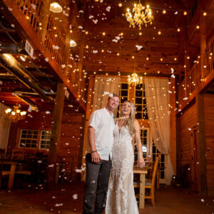 A bride and groom standing in a barn with confetti falling around them, celebrating with a Georgia corporate DJ service.