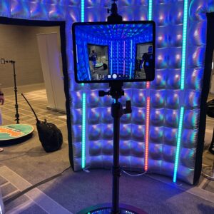 A person is using a tablet in a room with lights, exploring the best DJ service options for an upcoming corporate event in Georgia.