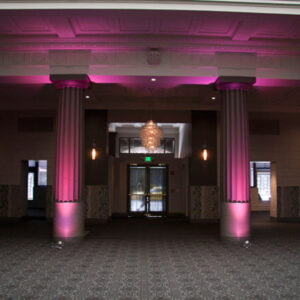 A large room with pink lighting and pillars, perfect for a Georgia wedding DJ setup.