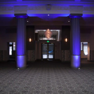 A large room with blue lighting and pillars, perfect for a Georgia wedding DJ setup.