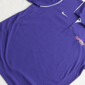 A purple Nike polo shirt on a bed at a Georgia wedding DJ service event.