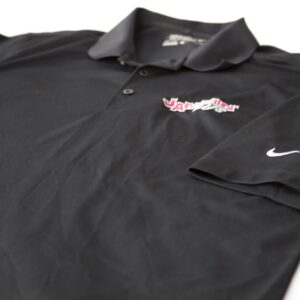 A black Nike polo shirt with a pink logo on it, perfect for a Georgia wedding DJ.