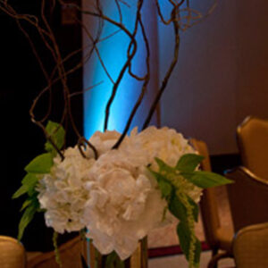 A gold vase with white flowers in it, perfect for a Georgia wedding DJ setup.