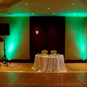 A room with green lighting and a table and chairs, perfect for a Georgia corporate DJ service.