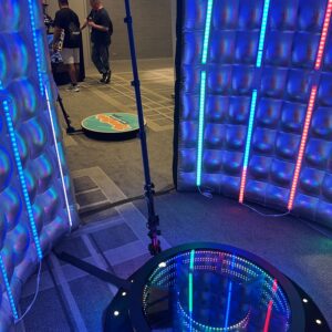 A group of people are standing in a room with lights, enjoying a Georgia corporate DJ service.